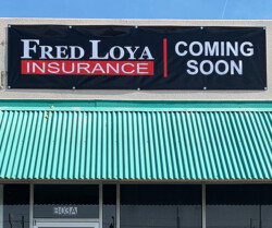 A banner saying "Fred Loya Insurance Coming Soon" is displayed on the facade of a building with a green corrugated metal awning.