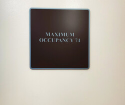 Sign on a wall indicating "Maximum Occupancy 74.