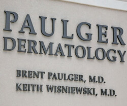 Sign for Paulger Dermatology displaying the names Brent Paulger, M.D., and Keith Wisniewski, M.D. on a building facade.