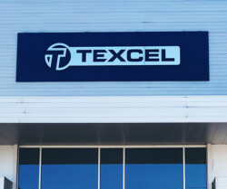 A building facade displaying a large, rectangular sign with the word "Texcel" in bold letters.
