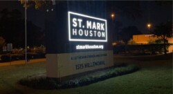 A lit sign at night displaying "St. Mark Houston," the website "stmarkhouston.org," and the address "1515 Hillendahl." The sign also notes it is a Lutheran church and school.