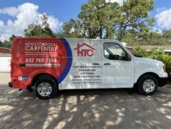 A white and red van is parked on a driveway. The van displays "Houston Total Carpentry" with contact details and services including custom residential, remodeling, additions, and new construction.